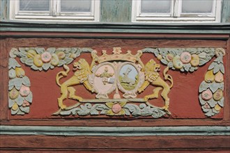 Wood carving of two yellow lion figures with crown at the house Zum goldenen Löwen, detail,