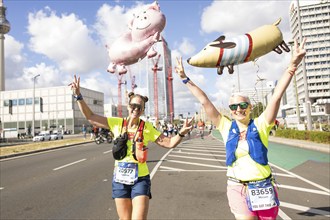 Runners with balloons in the shape of a pig and a dog on Karl-Marx-Allee at the 50th BMW Berlin