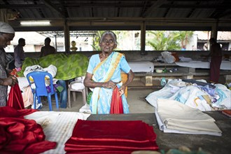 Indian woman folding laundry at Dhoby Khana laundry, Kochi, Kerala, India, Asia