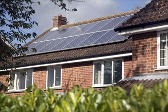 Large array of solar panels on domestic house roof