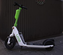 Electric scooter parked on the side of the road at the bike rental company Lime, OnLime and Uber,