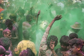 Revellers dancing in the beat of music as they celebrate Holi on a street, the Hindu spring