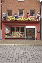 Shop window of a toy shop with oversized Playmobil figures in Warendorf, Warendorf district, North