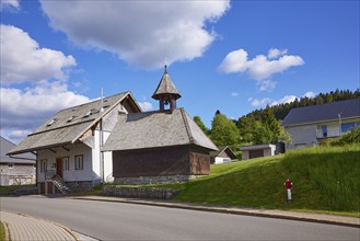 Chapel Unterlehen with road under blue sky with cumulus clouds in Bernau im Black Forest, Black