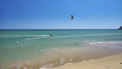 Kitesurfer rides on calm turquoise sea near the beach, surfer's paradise, kitesurfer, windsurfer,