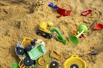 Sandpit, on a children's playground, sandpit with various plastic toys, excavator, shovels, moulds