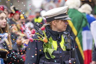 Rose Monday parade in Düsseldorf, policemen on duty at the street carnival, with flower