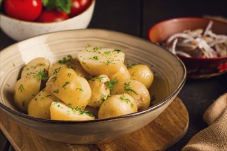 Frisch gekochte, neue Kartoffeln, mit Dill, auf einem Holztisch, selektiver Fokus. Nahaufnahme,