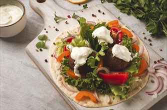 Tortilla with falafel and vegetable salad, white sauce, Arabic cuisine, top view, homemade, no