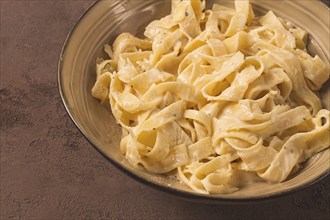 Fettuccine, tagliatelle, in creamy garlic sauce, Italian traditional cuisine, pasta carbonaro