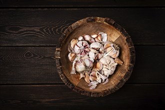 Fresh garlic, in a wooden plate, top view, close-up, no people