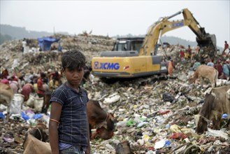 A rag picker posed for a photo at a garbage dumpsite, on the eve of World Environment Day, in