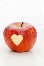 An apple with a heart, carved, symbol of love, Valentine's Day, Mother's Day, studio