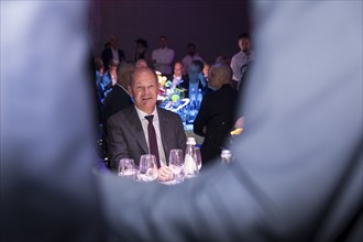 Olaf Scholz, Chancellor of the Federal Republic of Germany (SPD) framed by two people greeting each