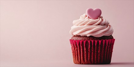 Cute velvet cake cupcake with pink frosting and heart on pink background with copy space.