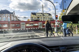 Barred level crossing, closed barrier, St Andrew's cross, traffic lights, S-Bahn train passing,