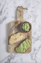 Ciabatta with avocado pasta, breakfast, on a chopping board, top view, homemade, no people