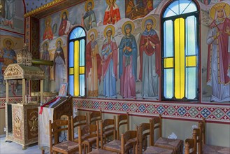 Orthodox church interior with icons, stained glass windows and wooden seating, Church of the