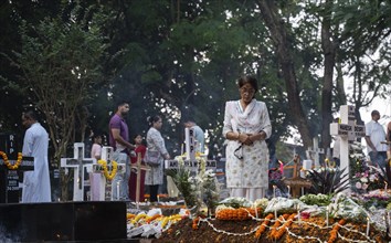 People from Christian community light candles and offer prayers on the grave of their relative