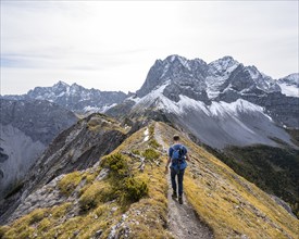 Mountaineer on a hiking trail on the ridge of Hahnkampl, mountain panorama with rocky steep peaks,