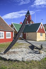 Historic building and anchor in front of blue sky, Museum, Sisimiut, West Greenland, Greenland,