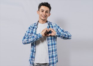 Smiling guy making heart shape with hands isolated. Happy man making heart shape with hands