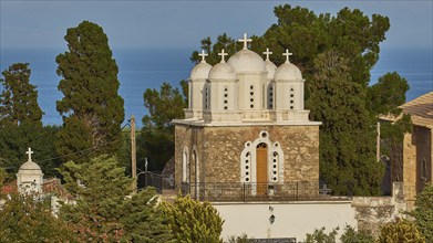 Frontal view of a church with white domes and a bell tower against a blue sky, Koroni, Byzantine