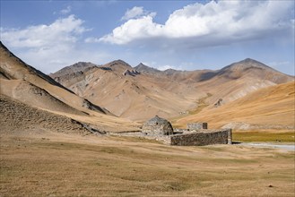 Historic caravanserai Tash Rabat from the 15th century, with yellow hills, Atbashy district in the