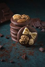 A stack of chocolate mediants, handmade candies, on a dark background, in the style of dark food,