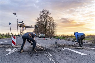 Climate activists chop up the asphalt of a road to erect obstacles, barricades, to prevent the