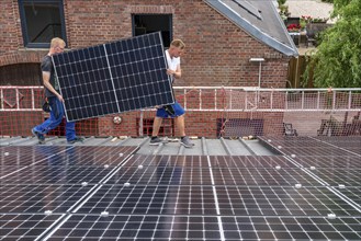 Installation of solar modules on the roof of a barn on a farm, over 210 photovoltaic modules are