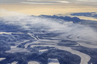 Aerial view of glaciers, glacier tongues and icy mountains on the coast, sunny, East Greenland,