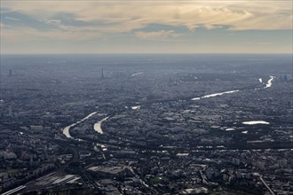 Spacious city with river course and clouds in the sky, flight, aerial view