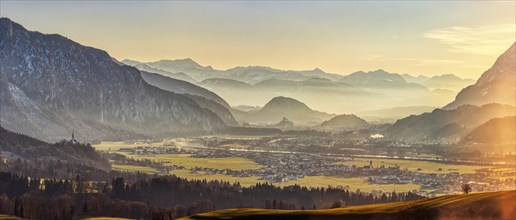 Picturesque Alpine landscape at sunset with mist in the valley, gentle rays of light and impressive