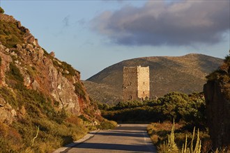 Warm evening sunlight illuminates a tower in a hilly landscape, residential tower, hotel, Mani