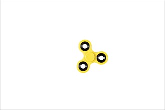 A yellow fidget spinner on a white background