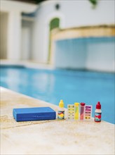 Chlorine and ph tester for swimming pools. Water test kit on the edge of the swimming pool.