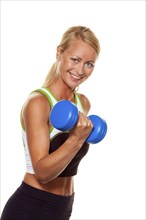 Blonde woman with dumbbell during training, studio