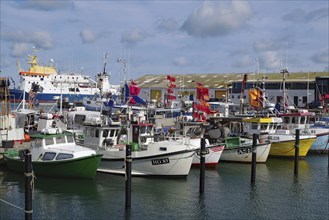 A collection of fishing boats in the harbour, surrounded by various flags and boathouses,