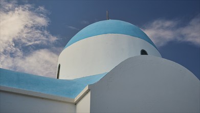 White-blue church with clouds in the background under a blue sky, Church of Profitis Ilias, above