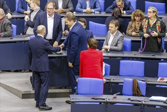 Olaf Scholz (SPD), Federal Chancellor, greets Lars Klingbeil in the plenary chamber in front of the