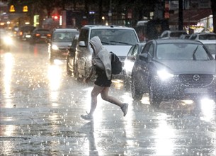 People try to protect themselves from the rain on Potsdamer Strasse. After weeks of heat, the first