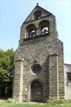 Saint-Pierre church and its distinctive comb bell tower in Arlet, Haute-Loire,