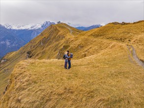 Couple hugging on a grassy hill with mountain backdrop, Alpen Tower, Switzerland, Europe