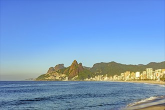 Ipanema Beach in the city of Rio de Janeiro at sunrise with the sea, buildings and mountains, Rio