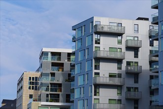 Modern residential building with glass balconies in an urban setting under blue skies, Bergen,