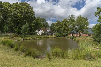 Manor house from 1920, in front the extinguishing pond, on the right the former horse stable,