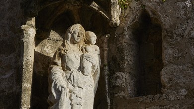 Church of Agia Triada, stone statue of a mother holding a child in an ancient and religious