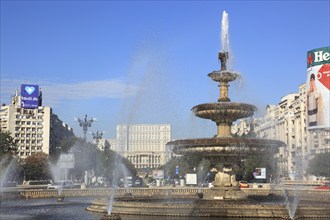 City centre, fountains and skyscrapers at Bulevardul Unirii, behind the Palace of Parliament,