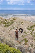 Traditional Kyrgyz eagle hunter hunting in the mountains in a dry landscape, near Kysyl-Suu, Issyk